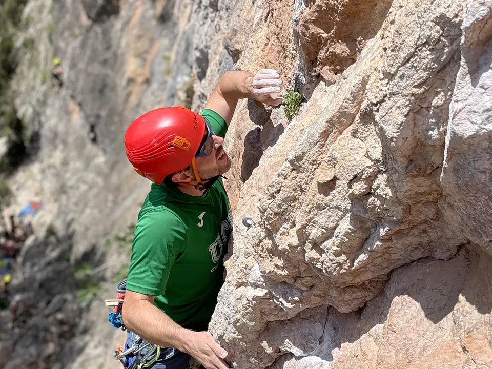 Escalador de primero progresando por una pared de roca caliza