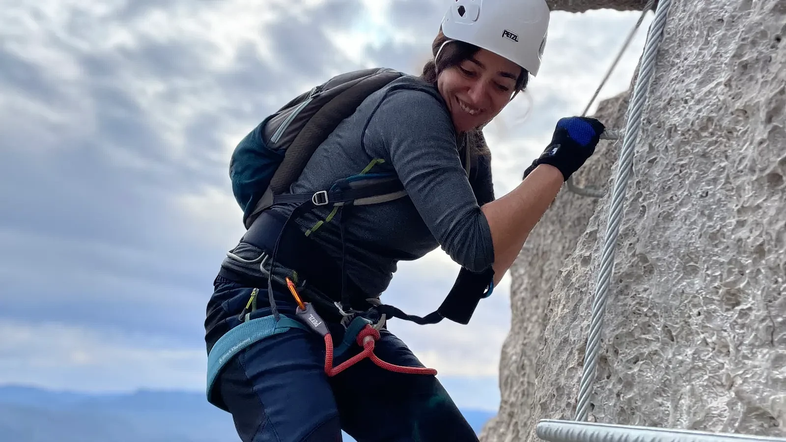 Participante progresando por una vía ferrata en el entorno montañoso de Chelva